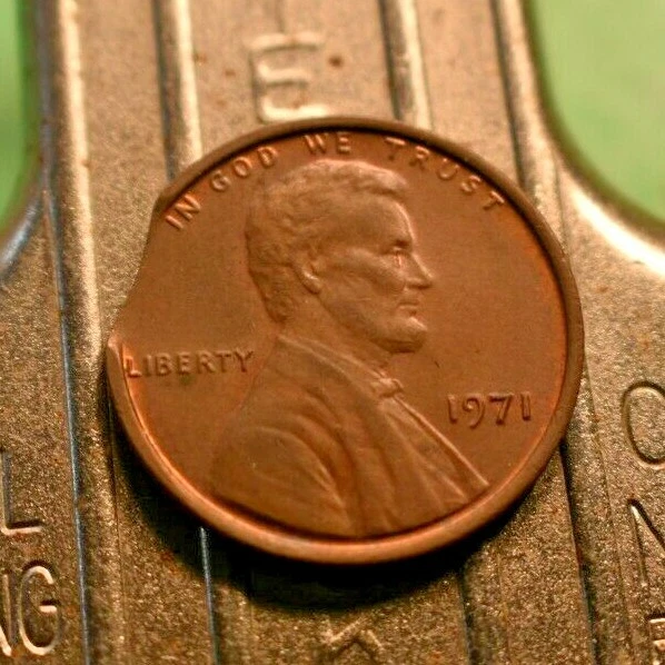 1971 penny clipped planchet error showing curved crescent-shaped section missing from the coin rim